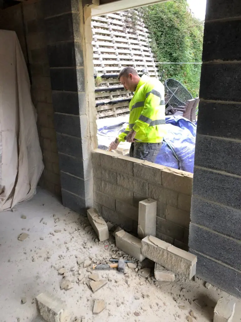 builder opening up exterior wall on garage conversion for doorway